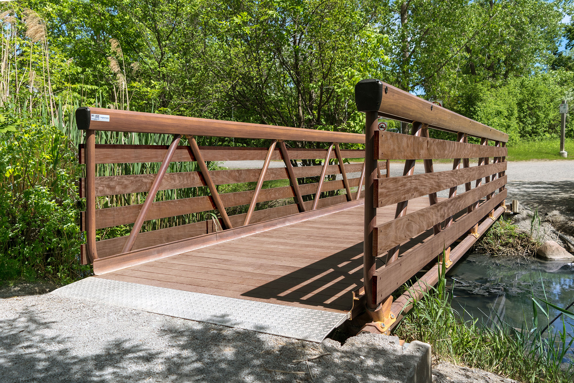 Aluminum weld-free pedestrian bridge with faux-wood finish in municipal park
