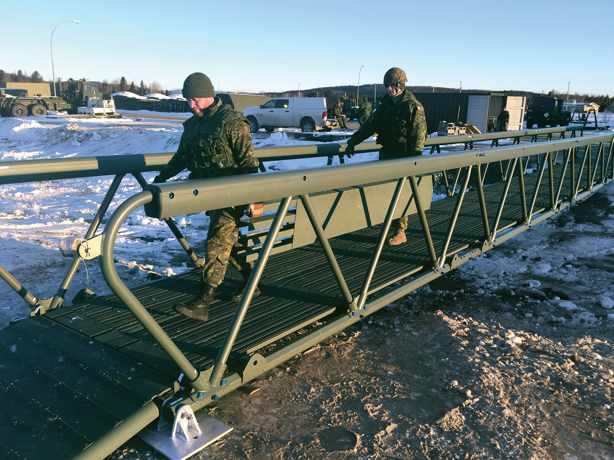 Soldiers walking across LVTB-1811 lightweight tactical bridge in snowy winter conditions
