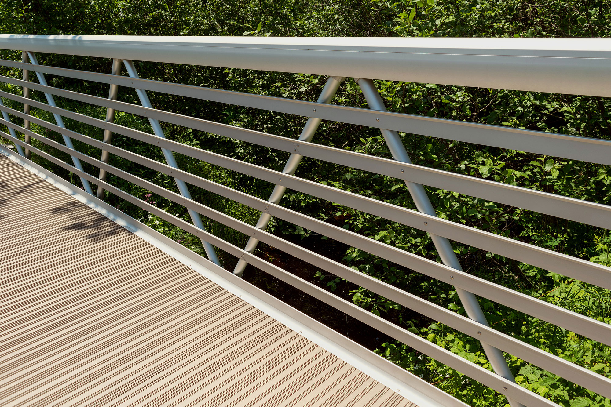 Weld-free pedestrian bridge with clear anodized finish guardrail and composite decking