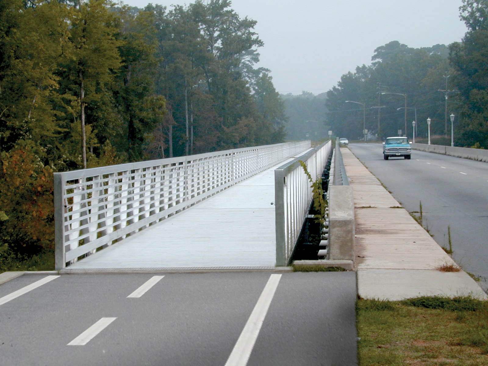 Custom aluminum cantilevered bridge used to retrofit bridge roadway for bike path