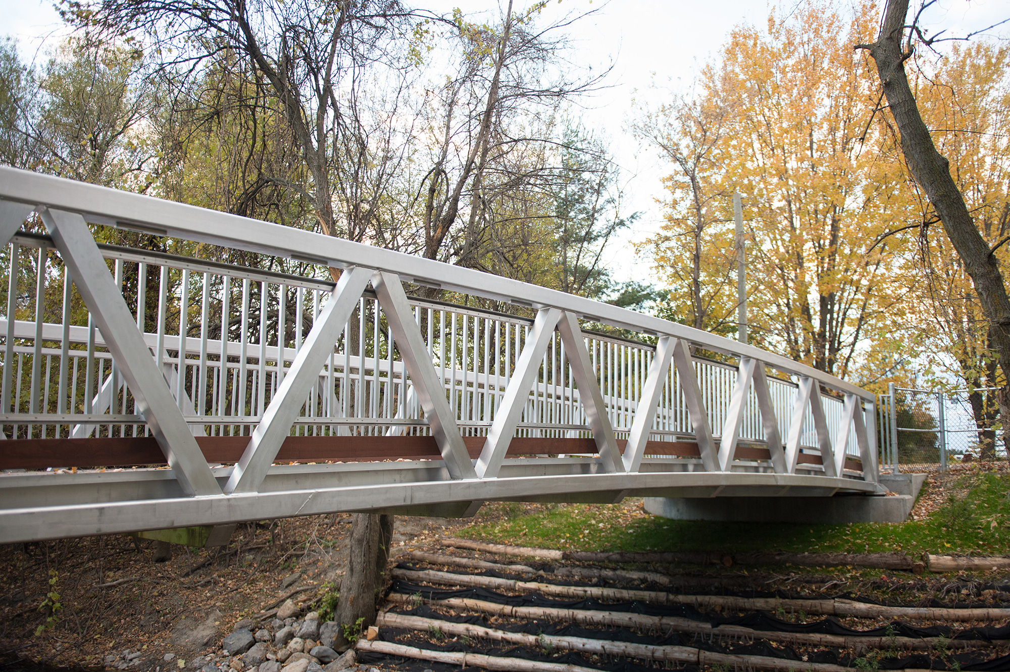 Custom aluminum pedestrian bridge with natural wood features in Canada