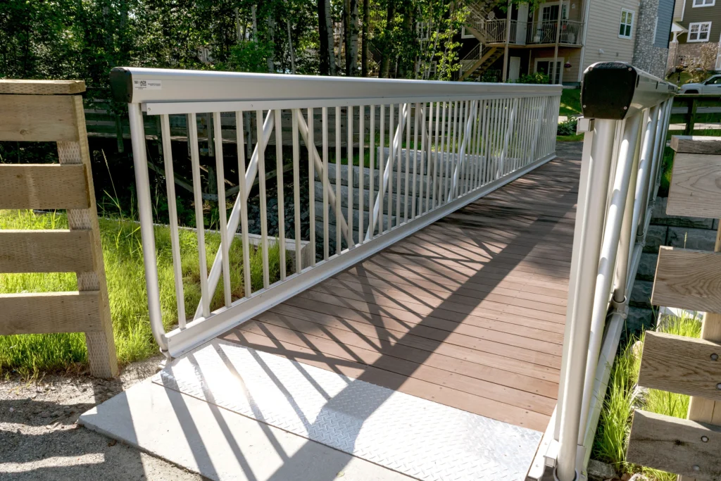 MakeABridge® modular aluminum pedestrian bridge installed in a residential area of Mont-Tremblant, Quebec, showcasing durability and sleek design