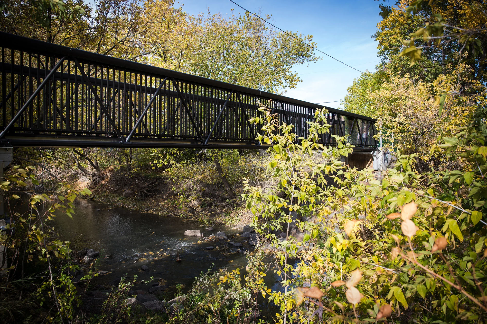 MakeABridge modular aluminum pedestrian bridge by MAADI Group crossing a river in St-Constant, Quebec.