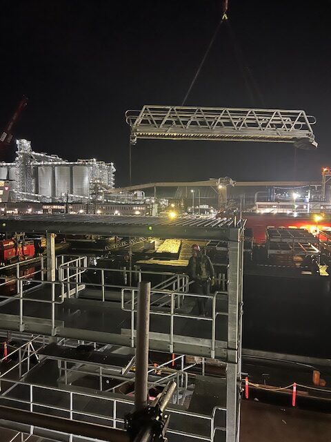 Aluminum gangway installation using crane under controlled conditions demonstrating compliance with engineering standards